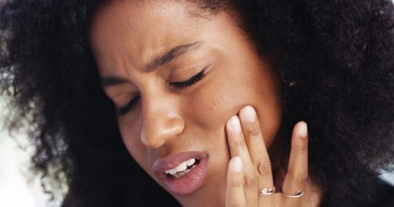 Toothache, sad and face of African woman at home for dental decay, poor oral hygiene and gum health pain. Gingivitis, bad breath and cavity bacteria with person for inflammation, tmj and crisis.