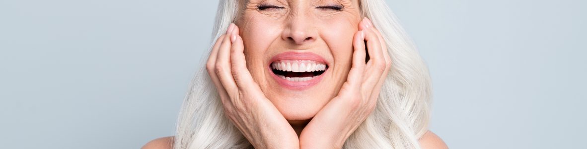 Close-up portrait of her she nice attractive excited cheerful grey-haired elderly lady touching cheeks laughing isolated gray pastel color background.