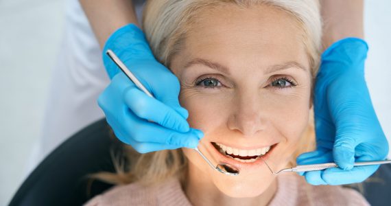 Close-up of pretty patient is having teeth examined by dentist in cabinet